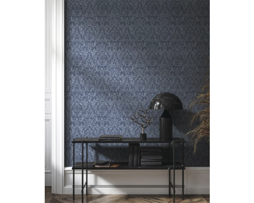 Raumansicht mit dunkel gemusterter Tapete, Konsole, Lampe und Dekoration