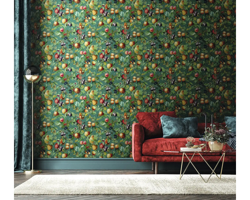 Wohnzimmer mit grüner Obsttapete, rotem Sofa und Teppich