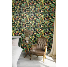 Schlafzimmer mit Bett, Sessel und Wandtapete mit Fruchtmotiven.