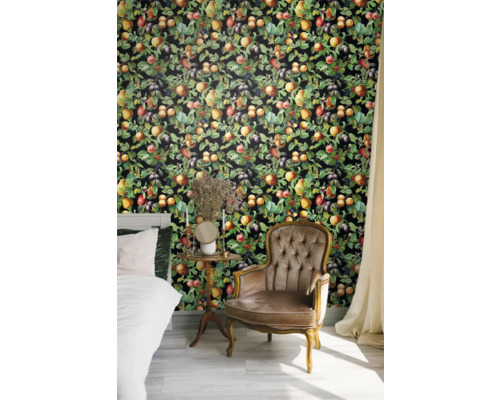 Schlafzimmer mit Bett, Sessel und Wandtapete mit Fruchtmotiven.