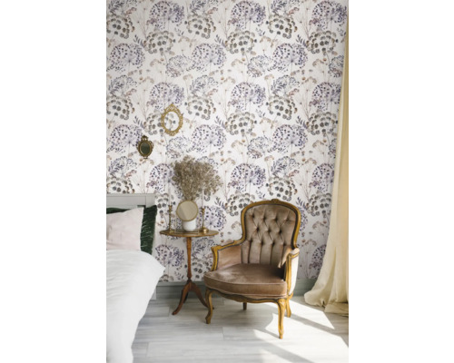 Dekoriertes Zimmer mit Bett, Sessel, Beistelltisch und floraler Tapete