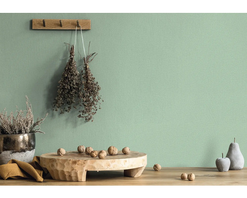 Helle, dekorative Wand mit Accessoires wie Trockenblumen, Holzbrett mit Nüssen, Obstattrappe und Topfpflanze