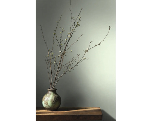 Dekorative Äste mit Blüten in einer Vase auf einem Tisch