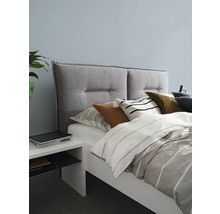 Schlafzimmer mit Bett, gepolstertem Kopfteil, Kissen und Nachttisch