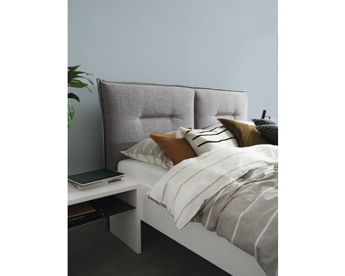 Schlafzimmer mit Bett, gepolstertem Kopfteil, Kissen und Nachttisch