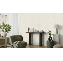Helles Wohnzimmer mit Sessel, Konsole und Dekorationsgegenständen.