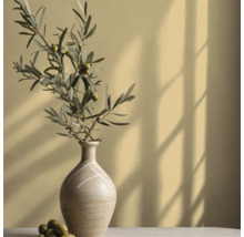 Dekorative Vase mit Olivenzweig auf Tisch