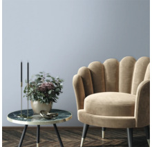Dekoratives Wohnzimmer mit Sessel und Beistelltisch mit Blumenschmuck.