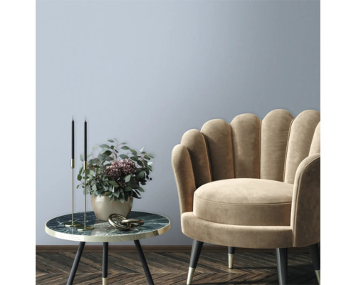 Dekoratives Wohnzimmer mit Sessel und Beistelltisch mit Blumenschmuck.