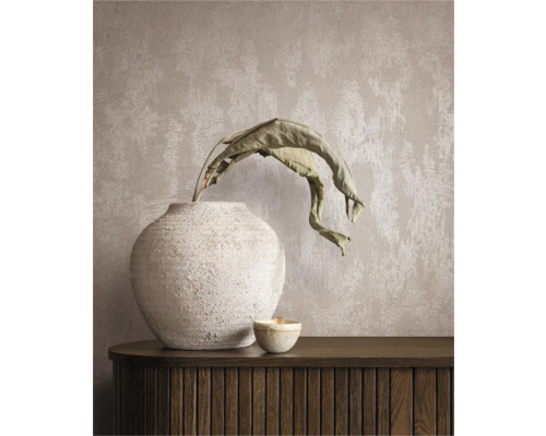 Dekoratives Stillleben mit Vase, Pflanze und Kerze auf einem Sideboard vor einer Wandtapete.