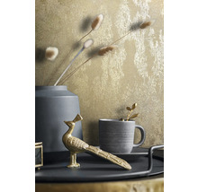 Dekorative Stillleben-Szene mit goldfarbener Tapete, Vase, Tasse und Pfauenfigur
