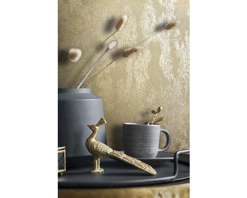 Dekorative Stillleben-Szene mit goldfarbener Tapete, Vase, Tasse und Pfauenfigur