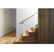 Treppe mit Holzstufen und Handlauf an einer weißen Wand