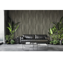 Wohnzimmer mit schwarzem Sofa, Couchtisch und dekorativer Wandverkleidung