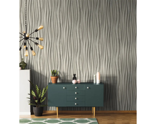 Wohnzimmer mit grauer Wandverkleidung in Wellenoptik, Sideboard und Lampe