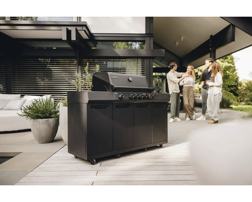 Schwarzer Gasgrill von Enders mit Unterschrank und vier Personen im Hintergrund