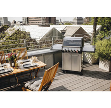 Gasgrill mit Tisch und Stühlen auf einer Dachterrasse
