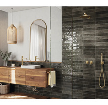 Badezimmer mit Waschtischunterschrank aus Holz, Spiegel, Dusche und Wandfliesen