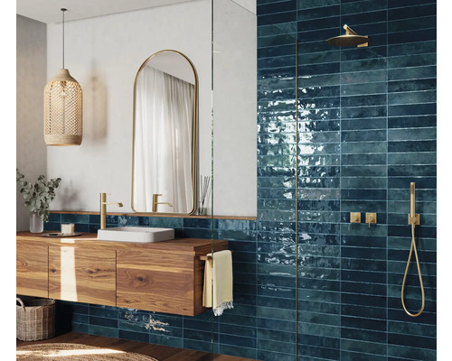 Modernes Badezimmer mit blauen Fliesen, Holzwaschtisch und goldenen Armaturen