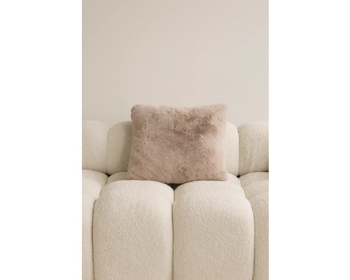 Quadratisches Zierkissen mit Felloptik auf einem Sofa.