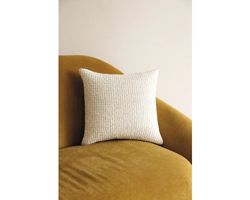 Quadratisches Dekokissen aus strukturiertem Stoff auf einem Sessel