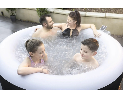 Familie entspannt in einem aufblasbaren Whirlpool im Garten.