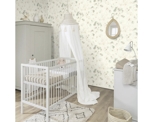 Helles Babyzimmer mit Kinderbett, Wickelkommode, Kleiderschrank und floraler Tapete