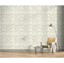 Wohnzimmer mit geometrischer Tapete, Sessel und Stehlampe.