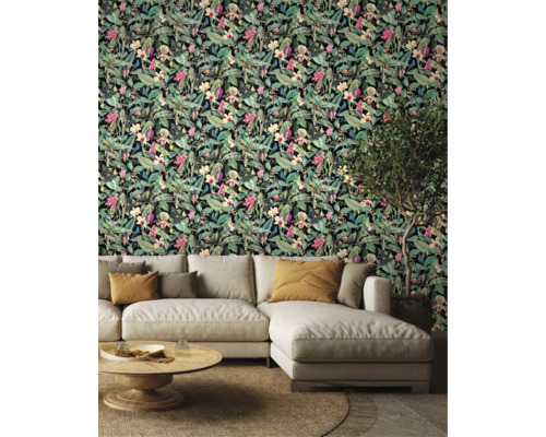 Wohnzimmer mit einer Wandtapete mit Blumen- und Blattmotiven und einem Sofa