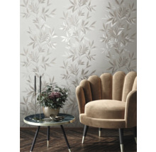 Dekorative Wand mit Blattmuster, Sessel und Beistelltisch im Wohnzimmer.