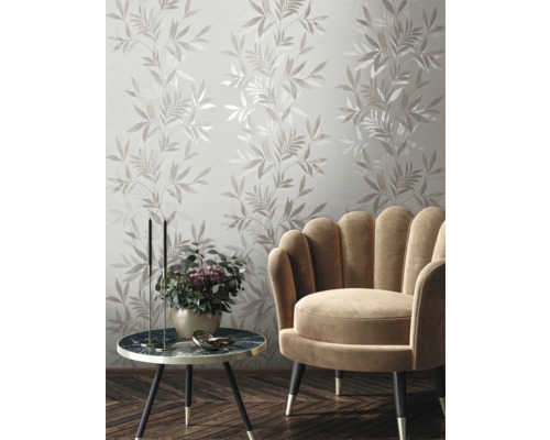 Dekorative Wand mit Blattmuster, Sessel und Beistelltisch im Wohnzimmer.