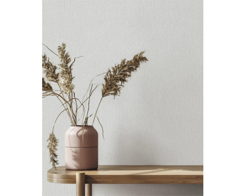 Dekorative Tapete mit Textilmuster und Vase mit Ziergras auf einem Holztisch