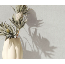 Dekorative Vase mit Protea-Blüten vor einer strukturierten Wand