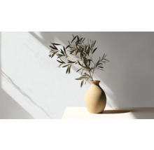 Dekorative Vase mit Pflanzenzweigen auf einem Tisch