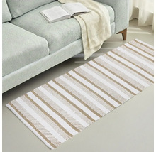 Teppich mit Streifenmuster neben einem Sofa mit einem offenen Buch