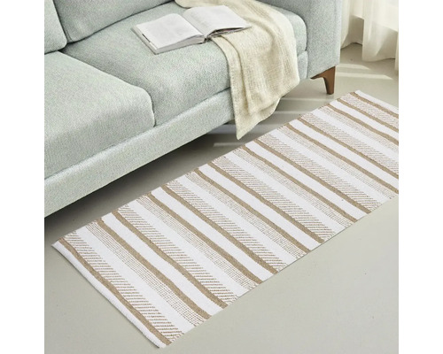 Teppich mit Streifenmuster neben einem Sofa mit einem offenen Buch