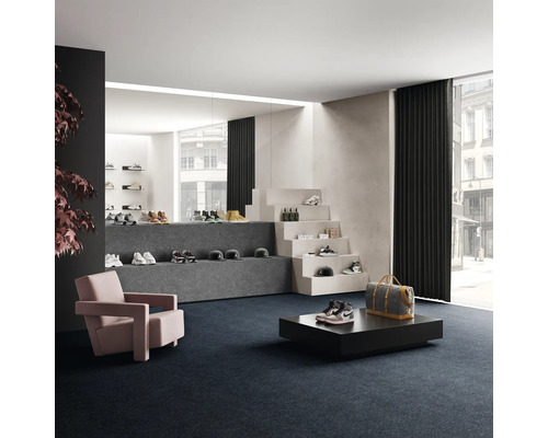 Verkaufsraum mit Schuhen auf Treppenstufen und Podesten, Sessel und Teppichboden