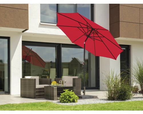 Szene im Garten mit rotem Sonnenschirm und Loungemöbeln