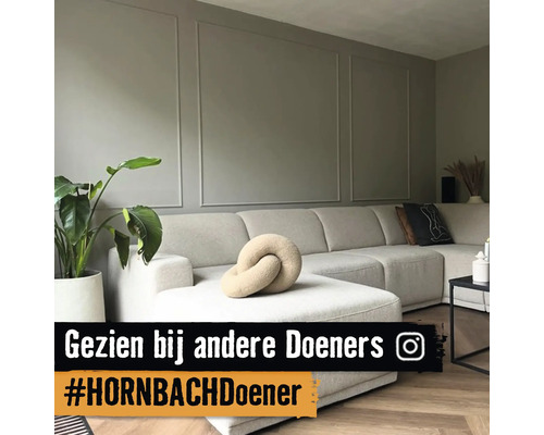 Wohnzimmer mit großem Ecksofa, Zimmerpflanze und Wandpaneelen