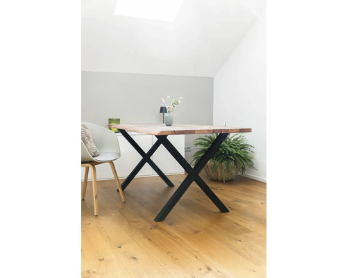 Esstisch mit Holzplatte und schwarzem X-förmigem Untergestell in einem hellen Raum