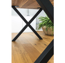 Tisch mit schwarzem Metallgestell und Holzboden