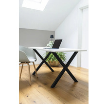 Schreibtisch mit Laptop, Lampe und Pflanze in hellem Raum.