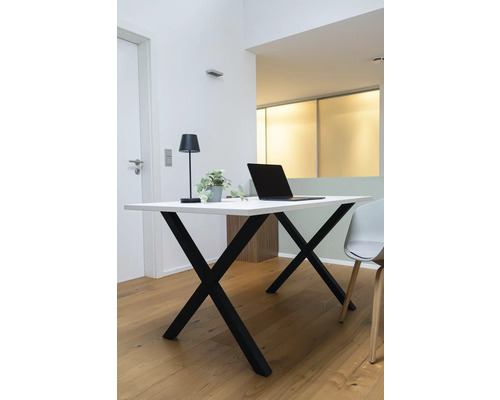 Arbeitsplatz mit Schreibtisch, Lampe und Laptop in einem hellen Raum