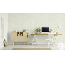 Ein Zimmer mit einer gemusterten Tapete, einem Schreibtisch, einem Stuhl und einem Schrank