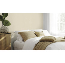 Helles Schlafzimmer mit Doppelbett, Nachttisch und Zimmerpflanze