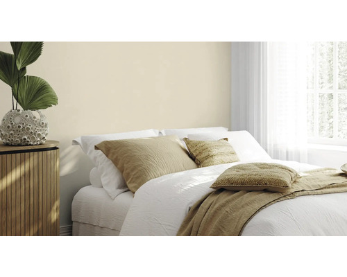Helles Schlafzimmer mit Doppelbett, Nachttisch und Zimmerpflanze