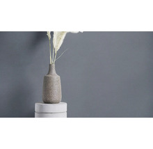 Dekorative Vase mit Pflanzen auf Podest