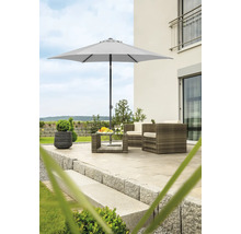 Gartenszene mit Sonnenschirm, Rattansesseln und Tisch auf einer Terrasse