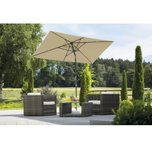 Gartenszene mit Rattanmöbelset, bestehend aus Sesseln, Tisch und einem rechteckigen Sonnenschirm