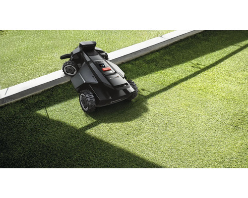 Rasenmähroboter auf Rasen neben Begrenzung